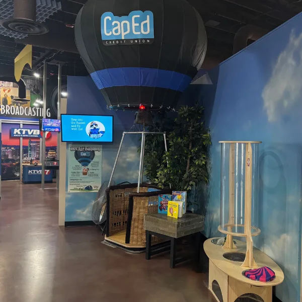 A hot air balloon basket kids can step inside, next to wind tubes with parachute figures
