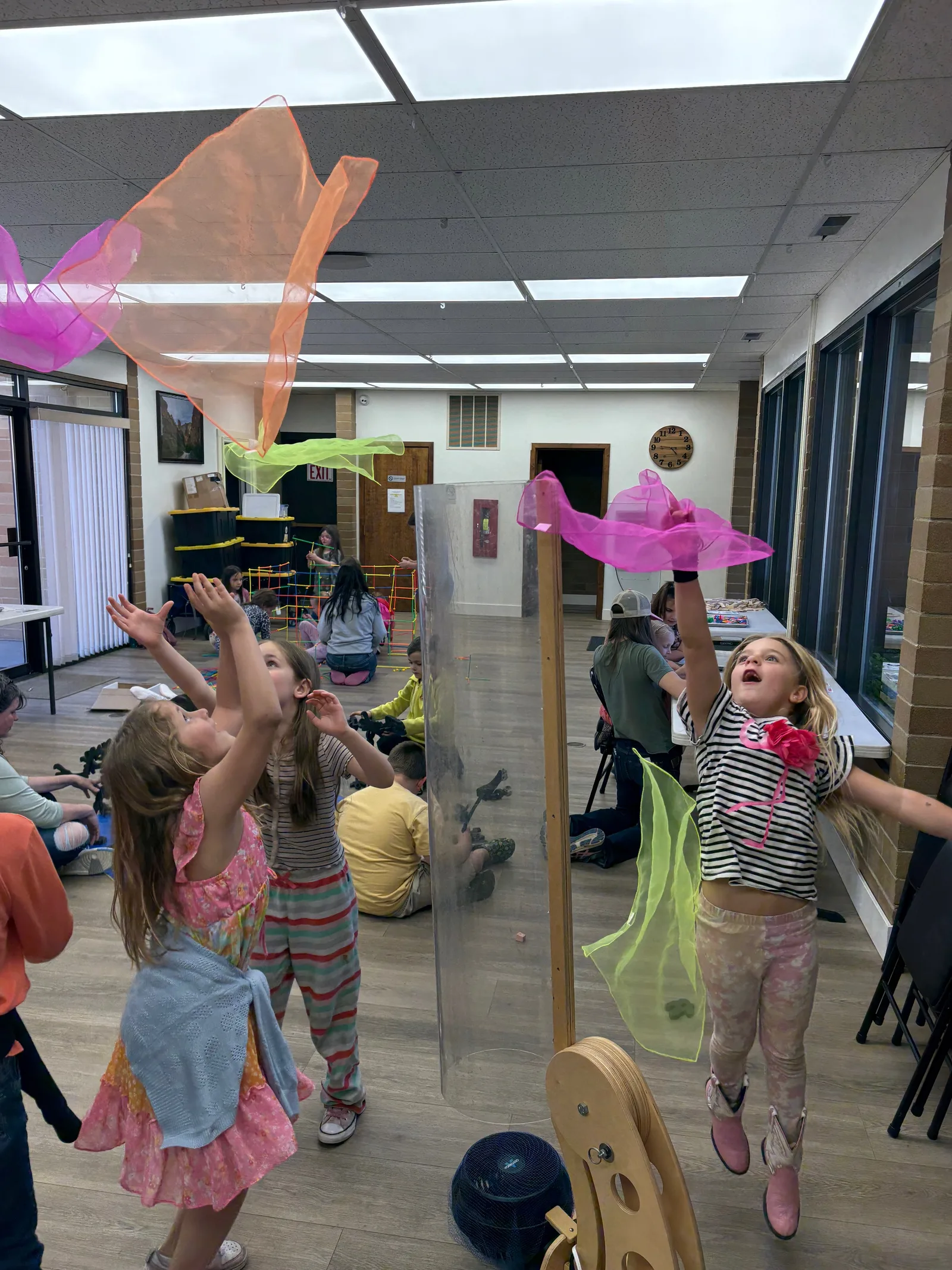 Kids with colorful scarves during a music-room activity.