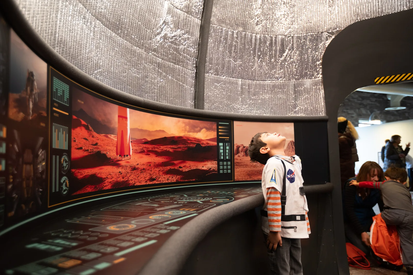 A boy exploring a Mars rover space-mission exhibit.