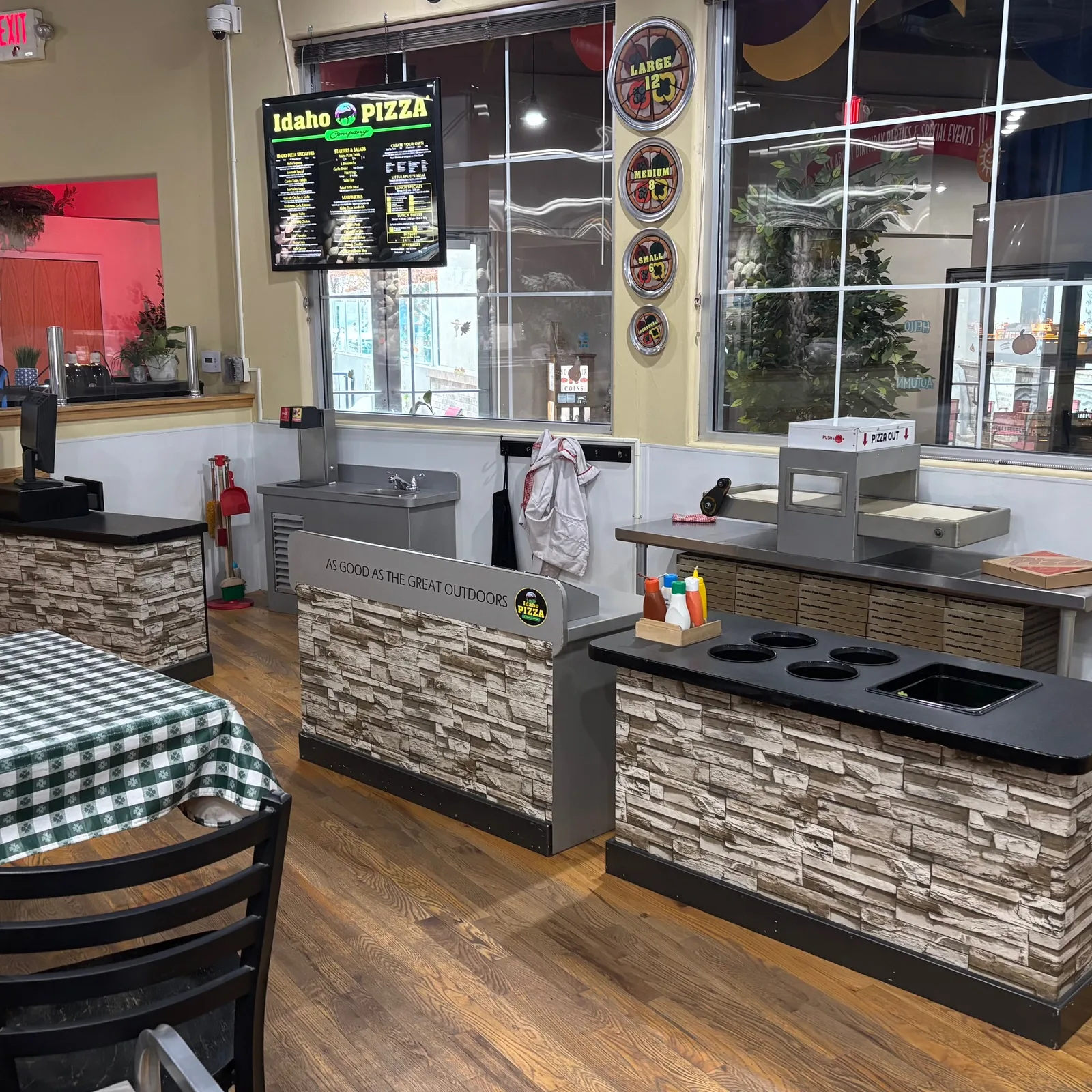Pretend play restaurant with felt pizzas, plastic salads, and tables and chairs.