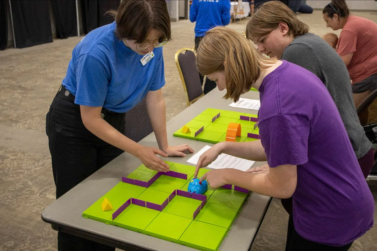 Kids working with a coding robot during a Museum on the Move STEM activity.