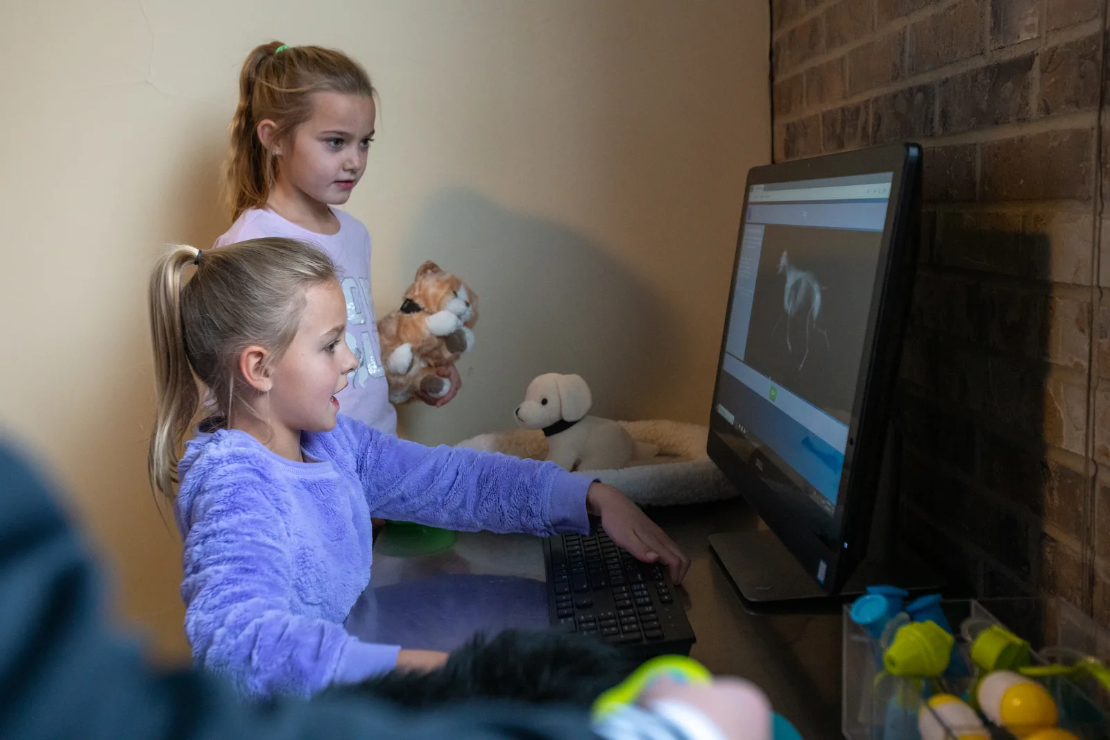 Two children at the museum's pretend veterinary clinic exhibit, playing on a computer together.
