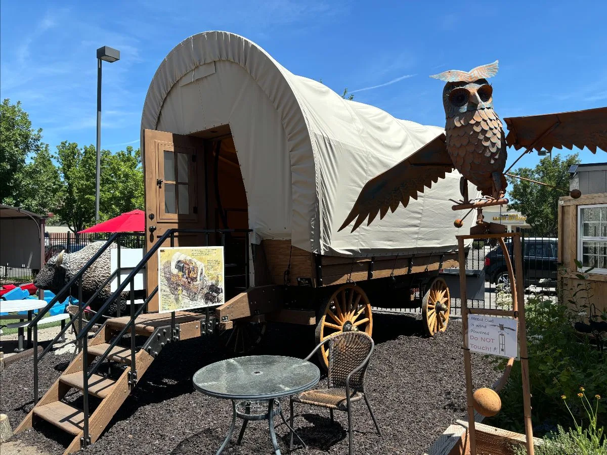 A canvas-covered Conestoga wagon outdoor exhibit — pioneer history for kids.