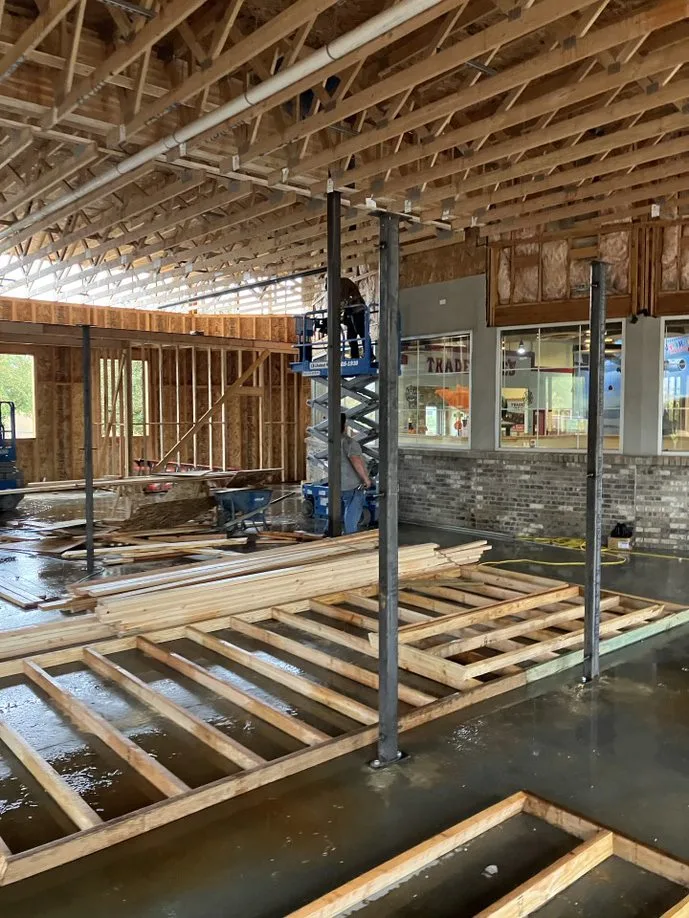 Interior framing of the museum expansion mid-construction, with a scissor lift.